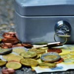 Caixa de segurança com moedas e notas de euro espalhadas, simbolizando a proteção financeira ao investir no Tesouro Direto para acelerar sua jornada financeira.